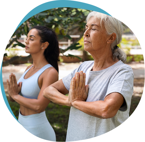 Two women practicing yoga outdoors