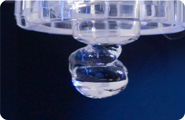 Close-up of viscoelastic hydrogel drop forming from a syringe